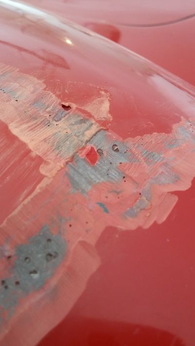 A close up of a red car with a lot of paint 
