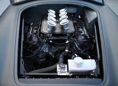 A close up of a car engine with the hood open