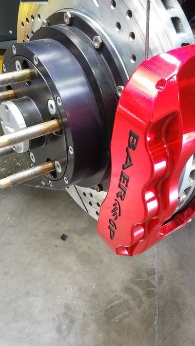 A close up of a red baer brake on a car