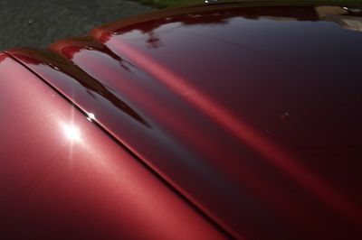 A close up of the hood of a red car