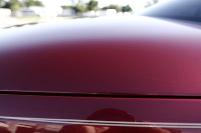 A close up of the hood of a red car