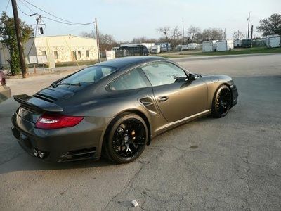 A gray sports car is parked on the side of the road