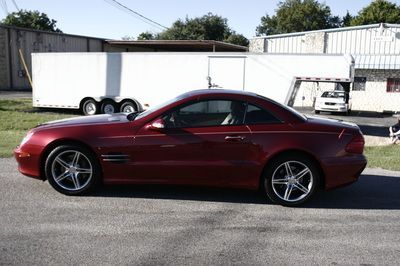 A red sports car is parked on the side of the road