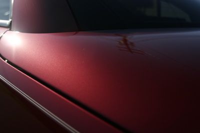 A close up of the hood of a red car