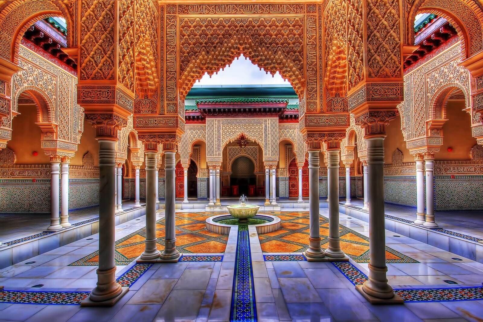 A building with columns and arches and a fountain in the middle