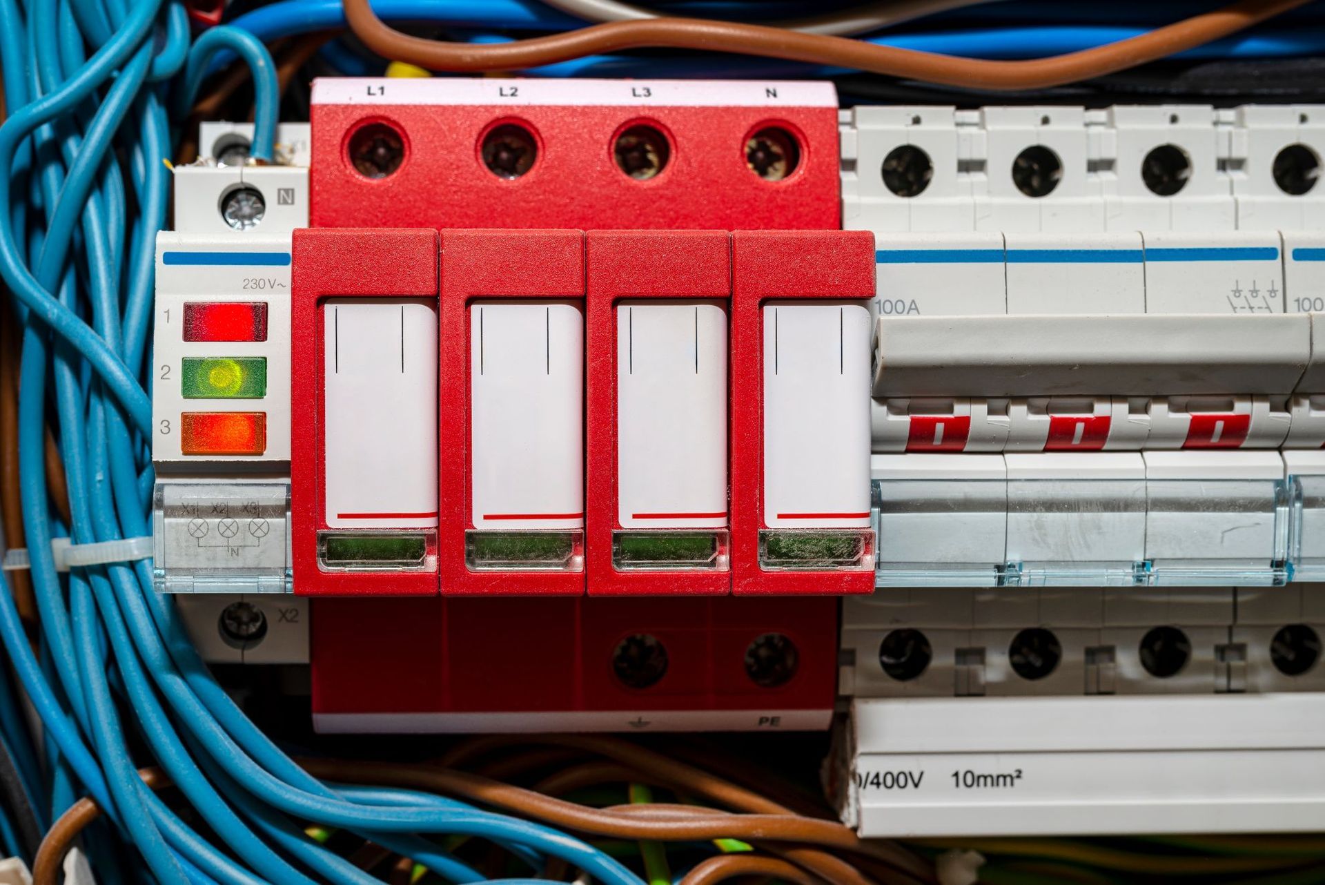 Red electrical circuit breakers with blue wiring in a control panel