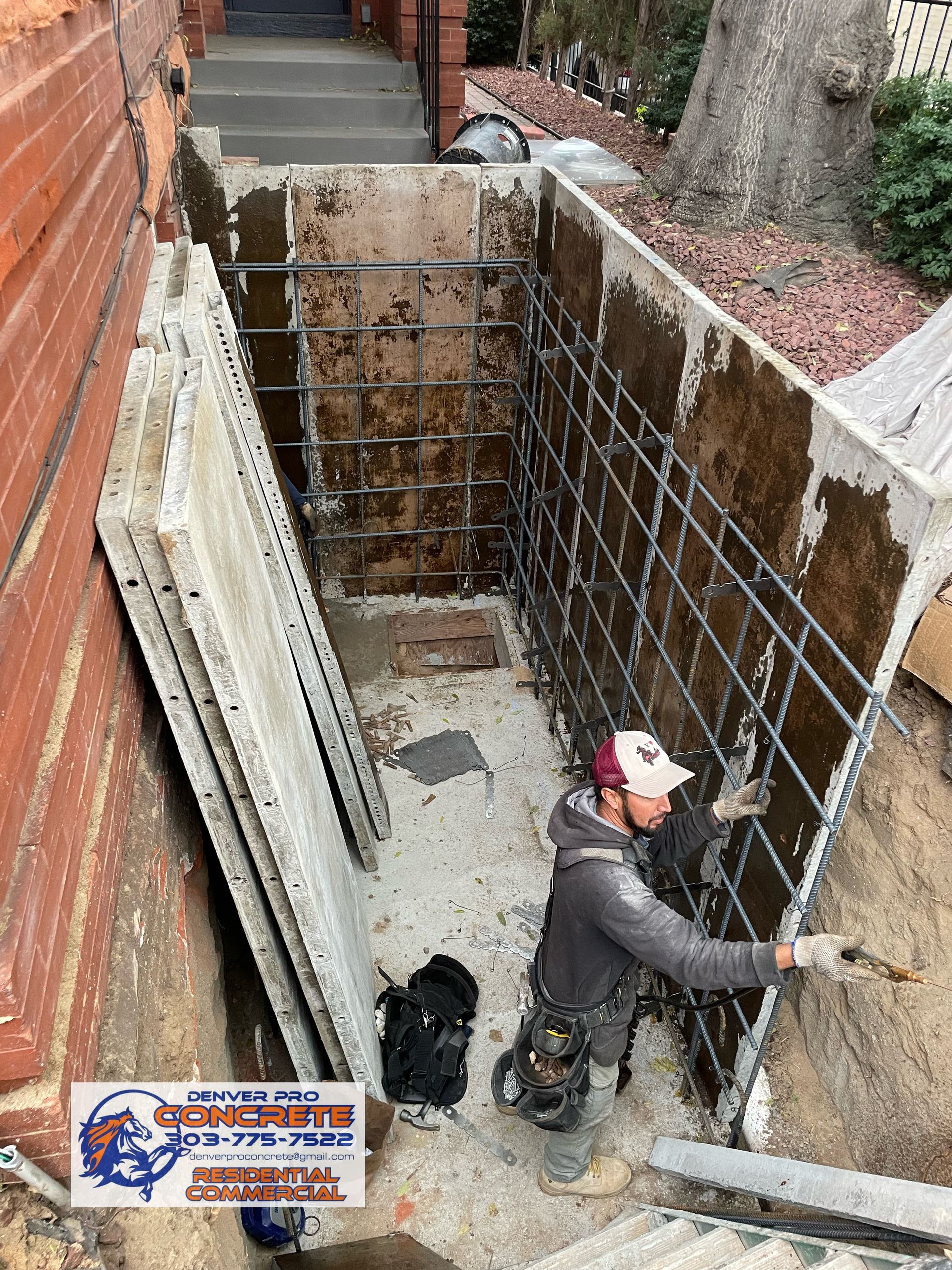 A man is working on a concrete wall in a basement.