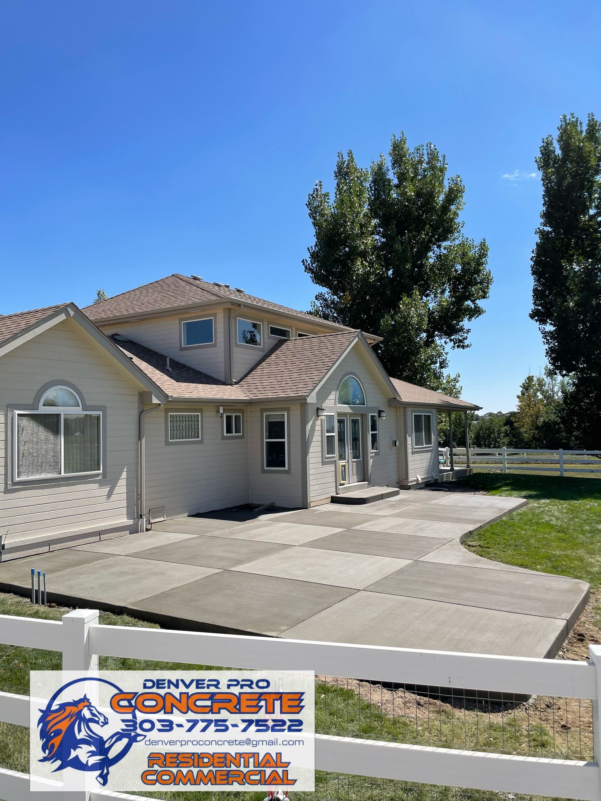A house with a white fence and a sign that says denver pro concrete
