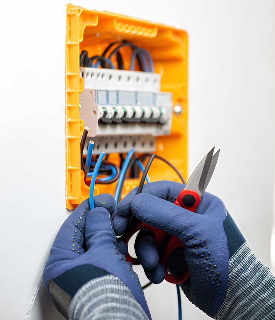 A Person Is Working On An Electrical Box With A Pair Of Scissors — Steve Mason Electrical In Laurieton, NSW
