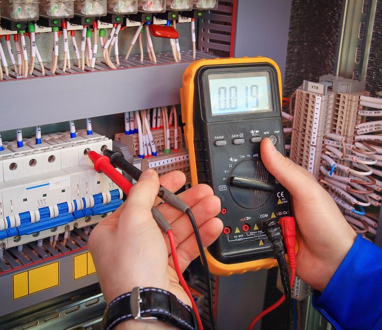 A Person Is Using A Multimeter To Check A Circuit Board — Steve Mason Electrical In Wauchope, NSW 
