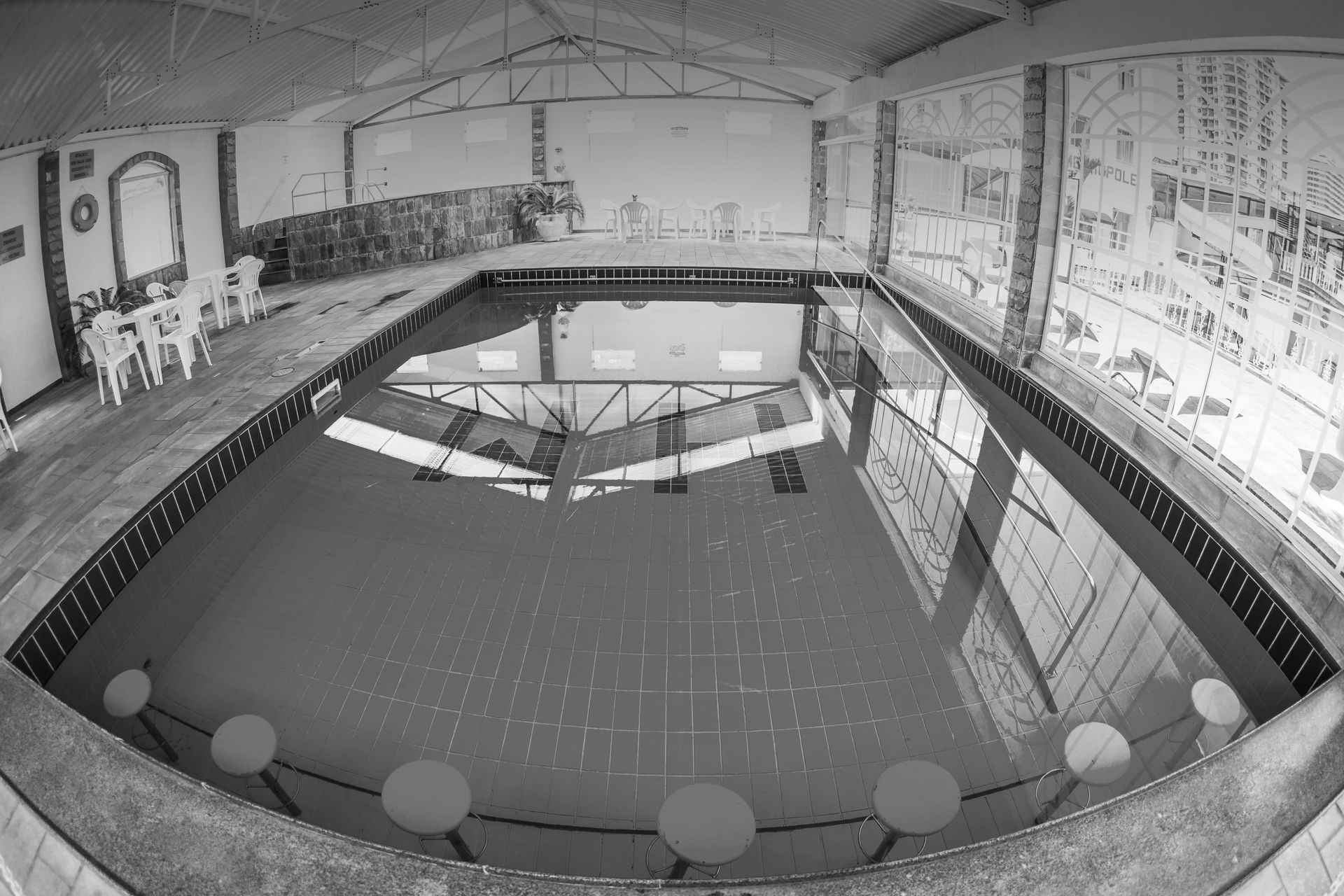 Uma foto em preto e branco de uma piscina coberta
