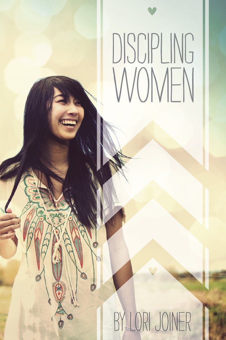 A woman in a white dress is standing in a field and smiling.