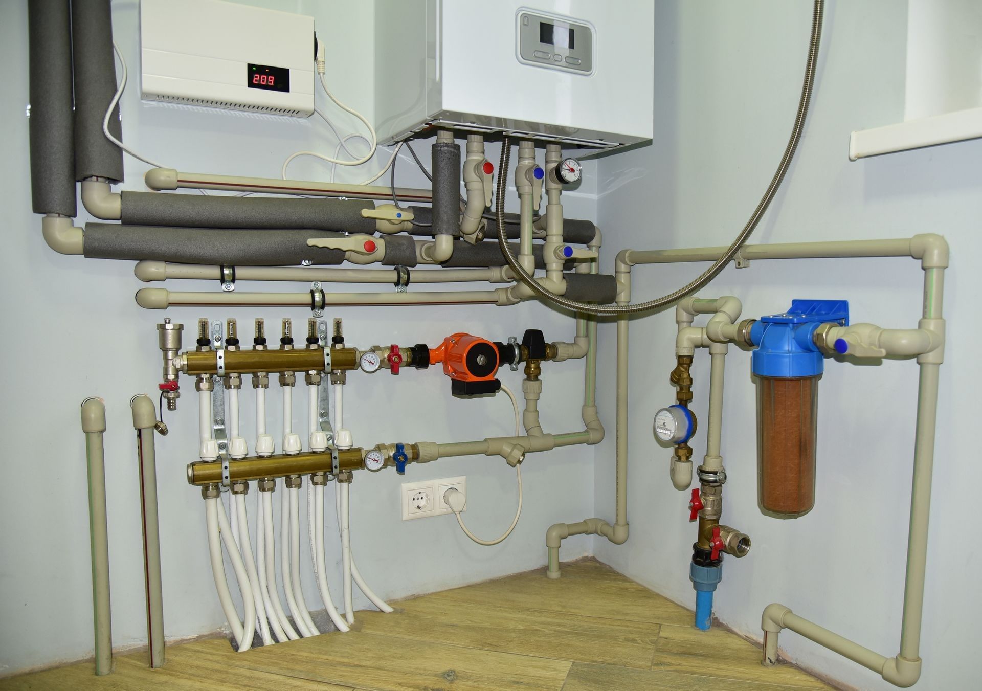 Plumbing system with a water heater, pump, filters, and pipes in a room, possibly a utility room.