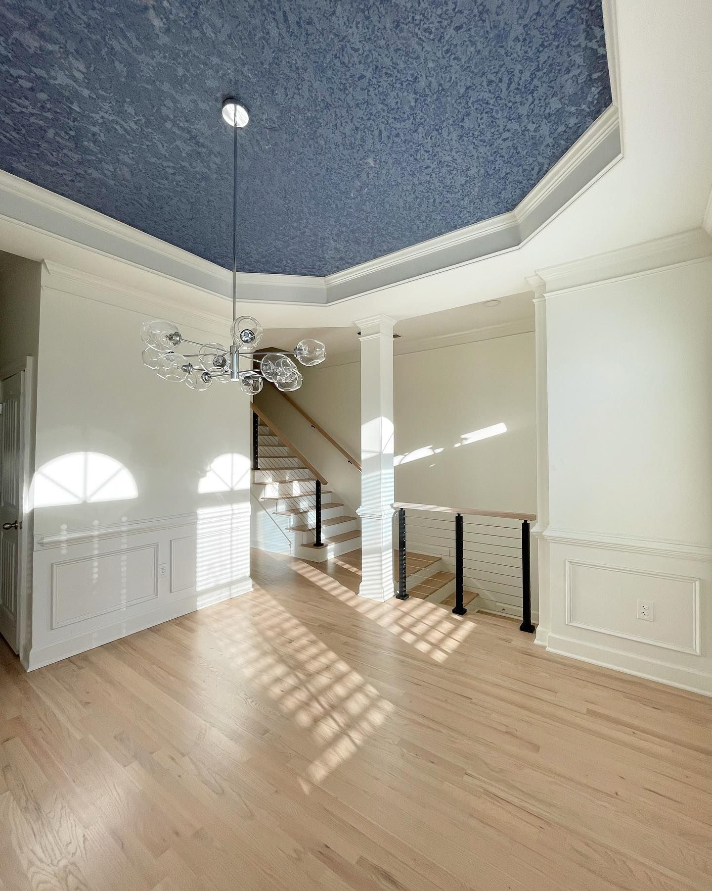 An empty room with a blue ceiling and stairs