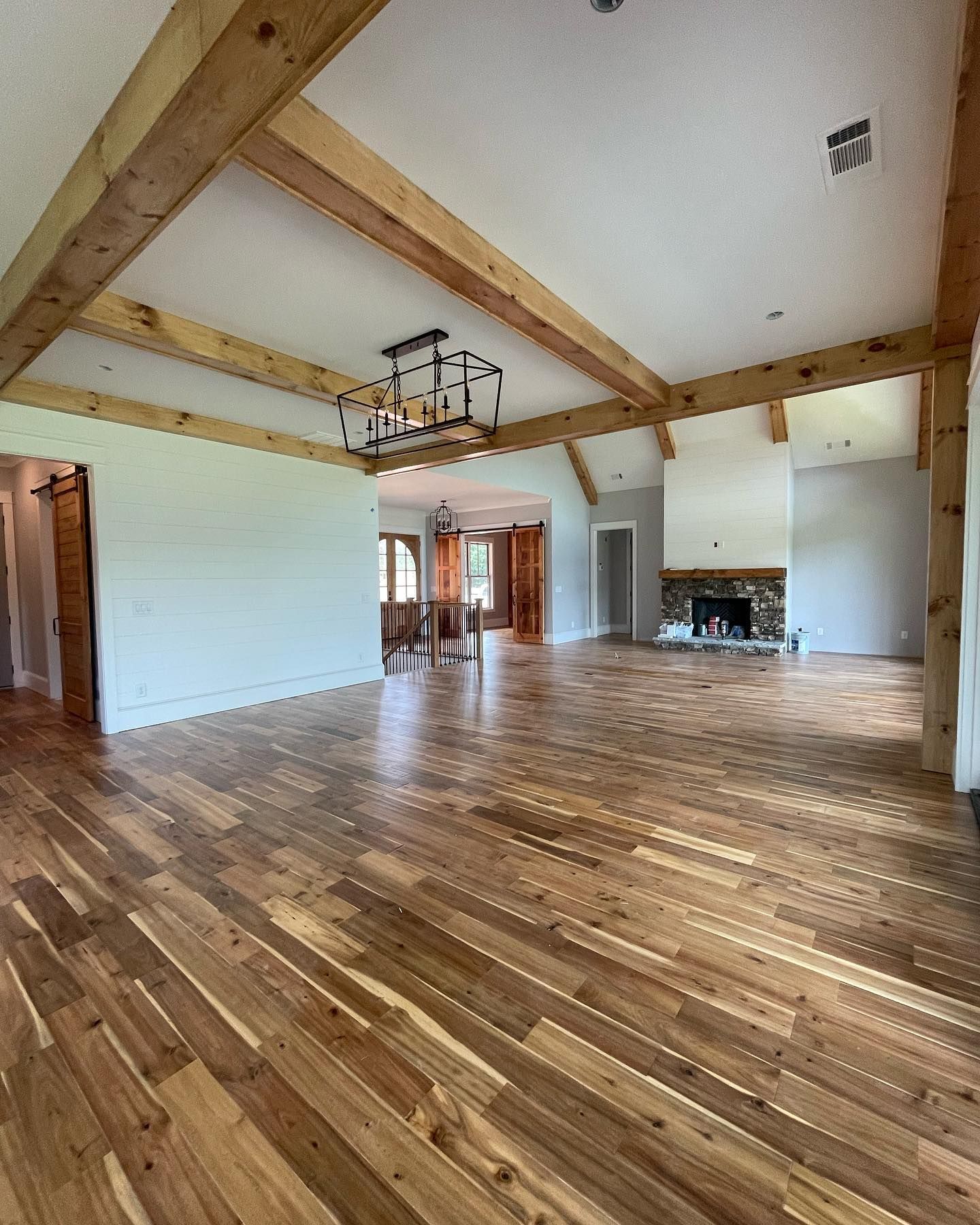 A large empty room with hardwood floors and a fireplace.