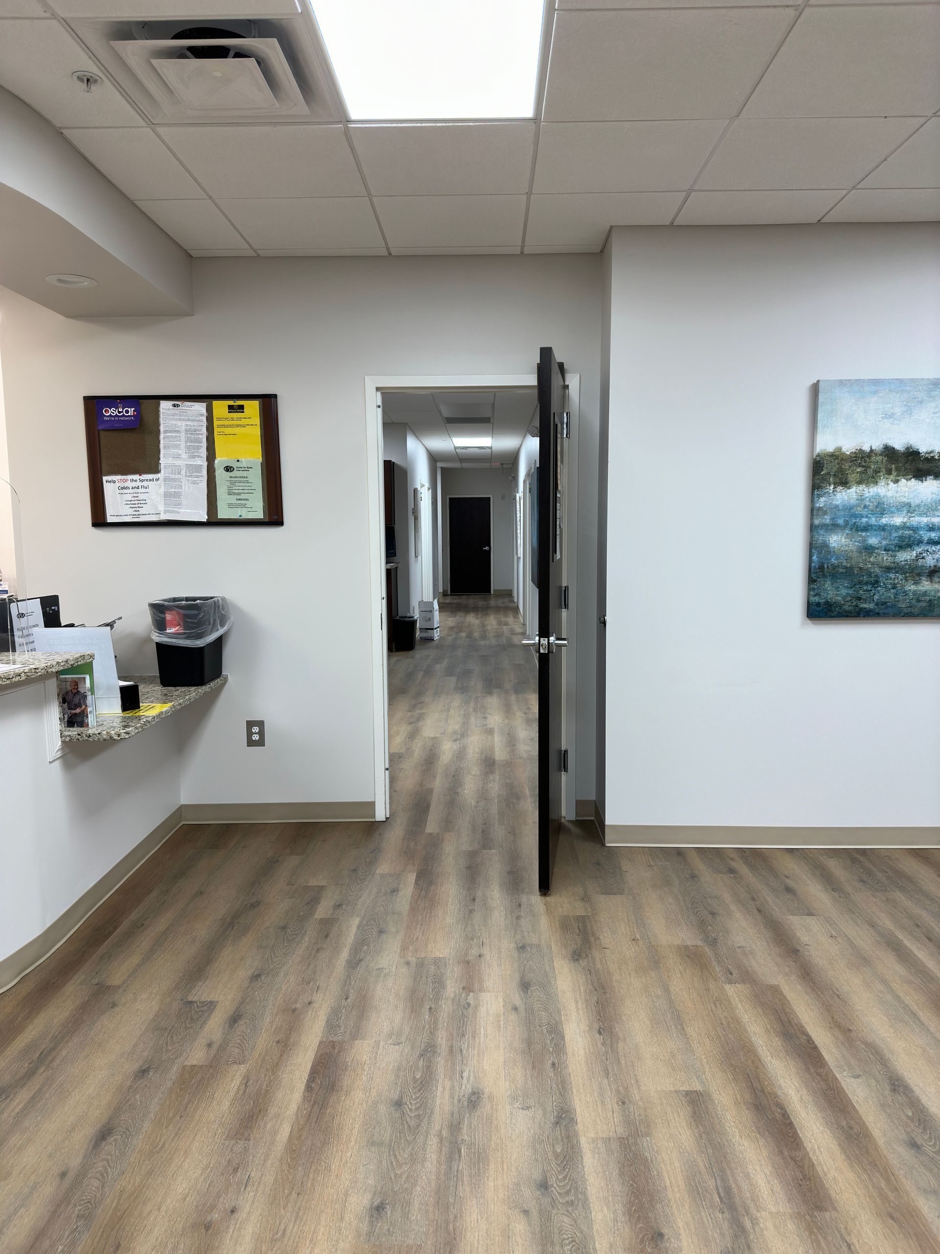 A long hallway with lvt flooring and vinyl base