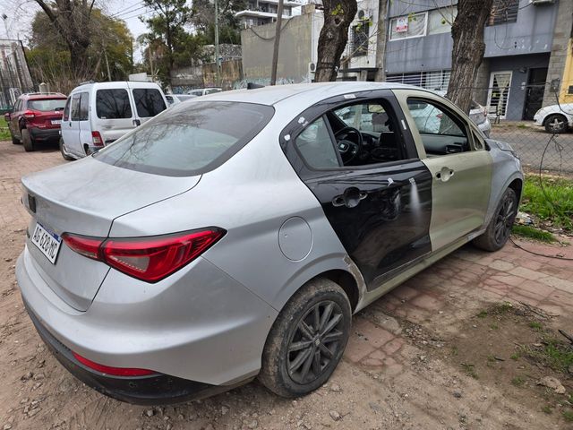 Coche azul en un taller, cubierto con plástico protector para pintar o reparar.
