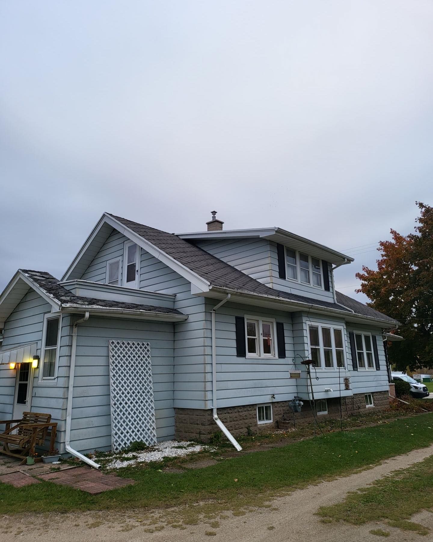 A house with a roof that has a chimney on it.