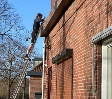 Young man is cleaning the gutter before the coming rain