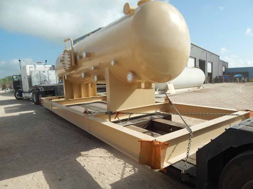 A large tank is sitting on the ground next to a truck