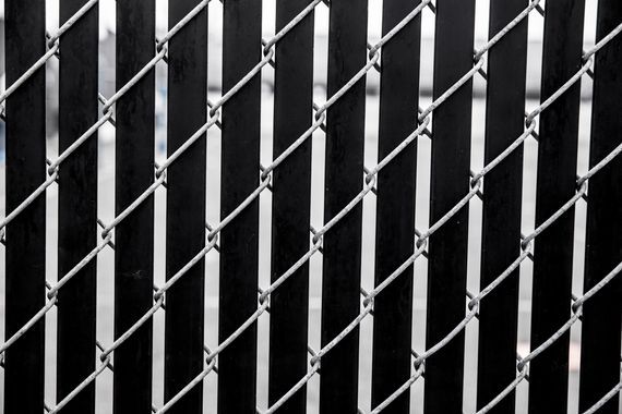 Closed metal accordion security gate against a dark background