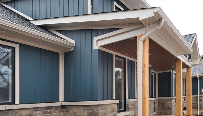 a blue and white house with a porch and gutters