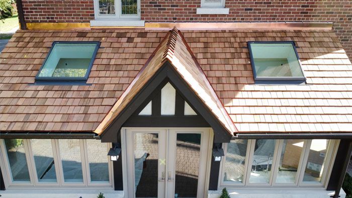 an aerial view of a house with a wooden roof and skylights