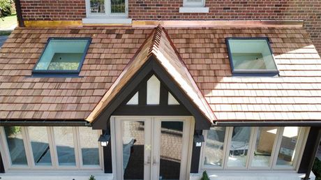 an aerial view of a house with a wooden roof and skylights