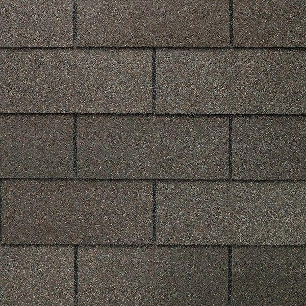 Close-up of gray asphalt roof shingles in a staggered pattern