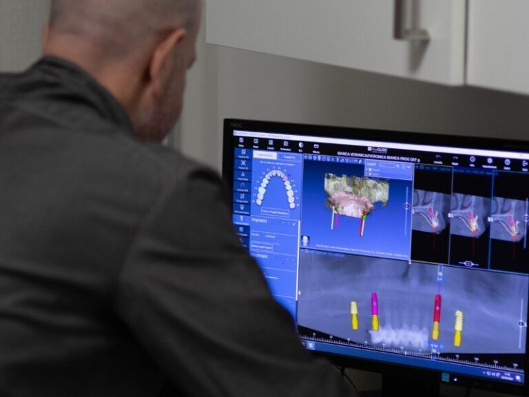 Persona che visualizza immagini diagnostiche su un monitor in un ambiente clinico.