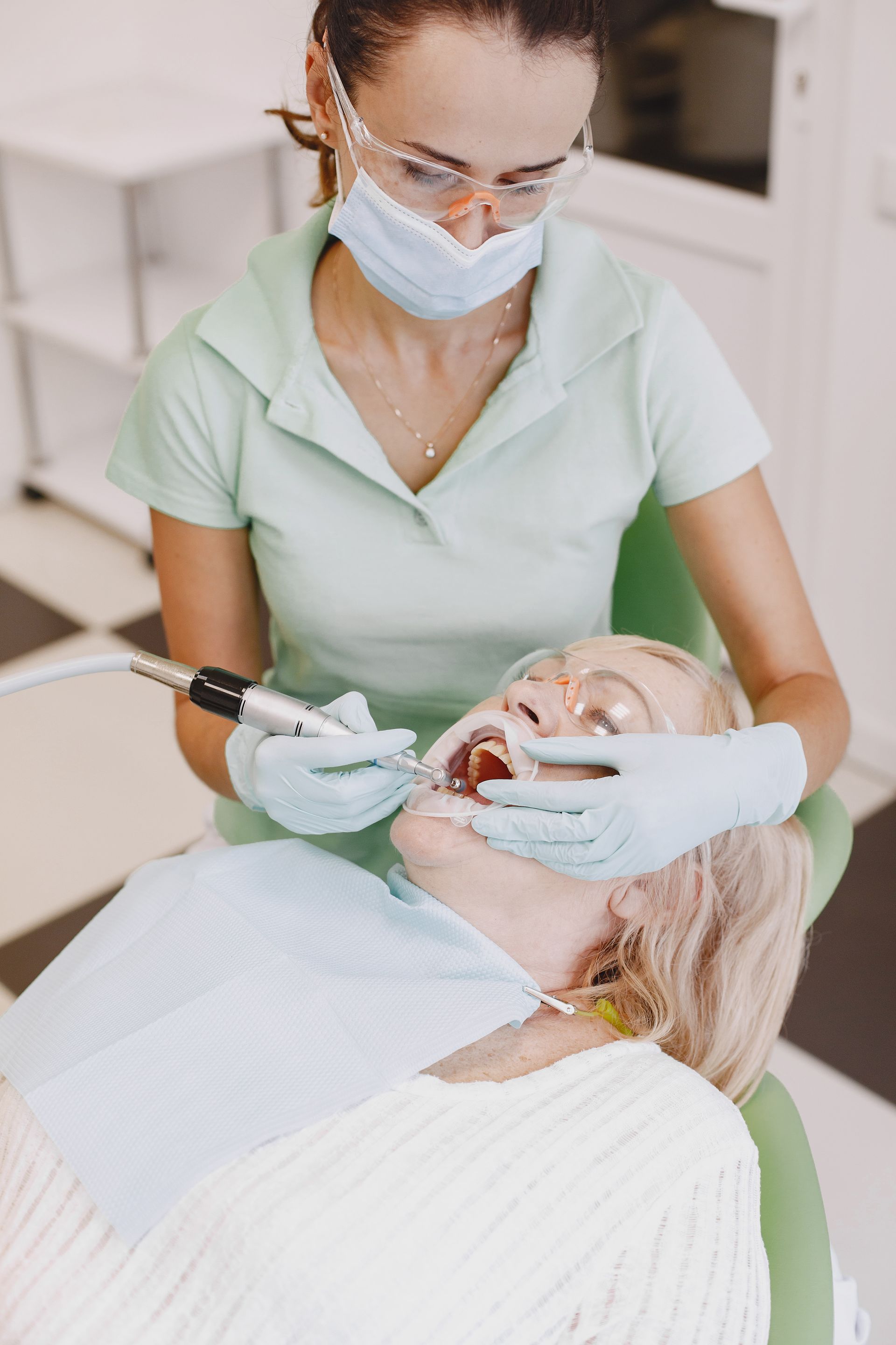 Una persona indica un modello dentale sullo schermo di un computer in un ufficio luminoso.
