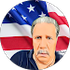 A man with a mustache is standing in front of an american flag.