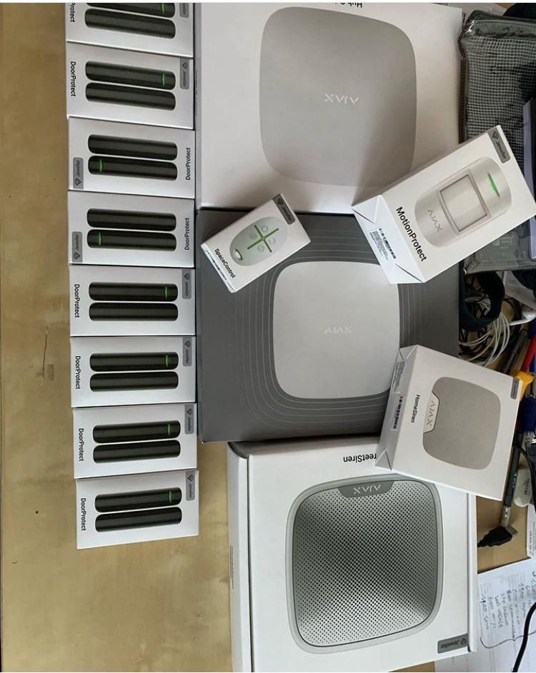 Su un tavolo sono disposti vari dispositivi per la casa intelligente e componenti confezionati, tra cui router e altoparlanti.
