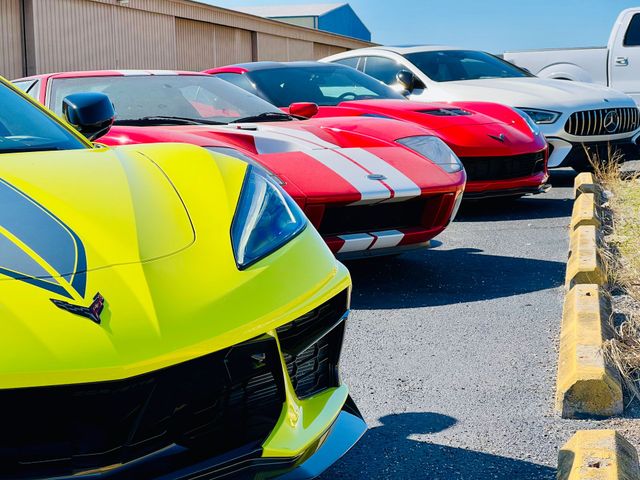 A row of sports cars are parked next to each other in a parking lot.