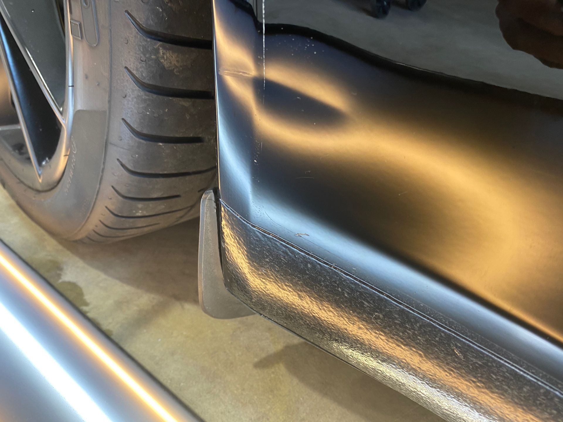 A close up of the side of a car with a damaged bumper