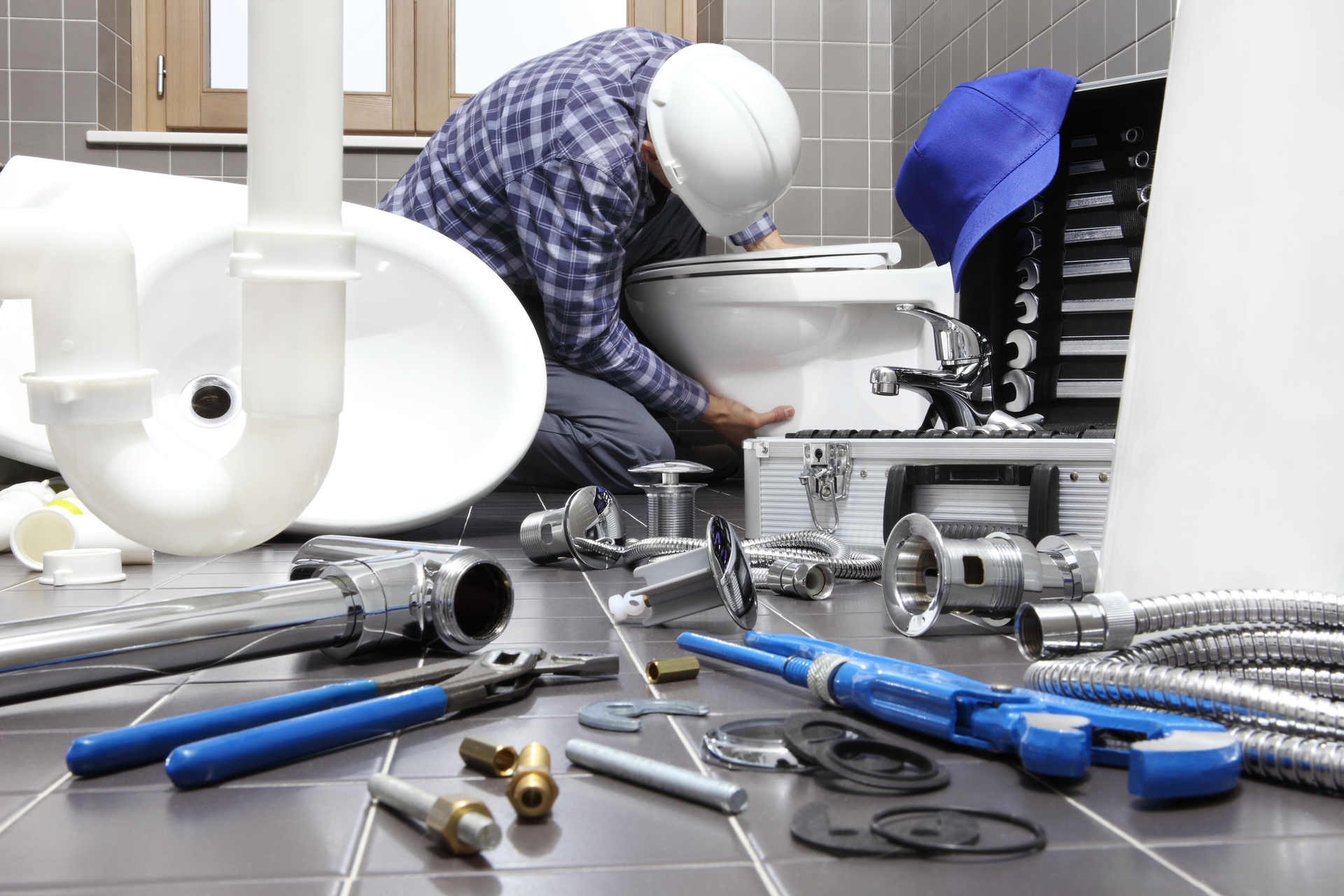 An experienced plumber installing bathroom fixtures for a renovation plumbing job.