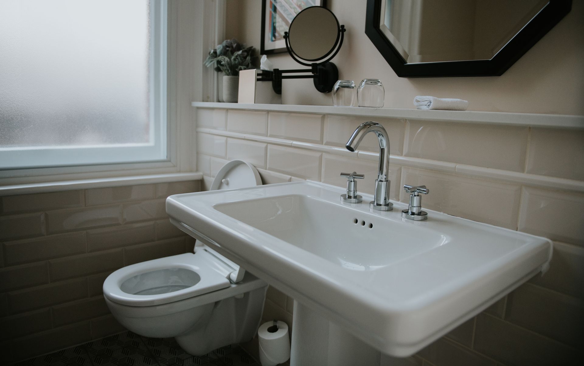 A bathroom with a toilet , sink and mirror.