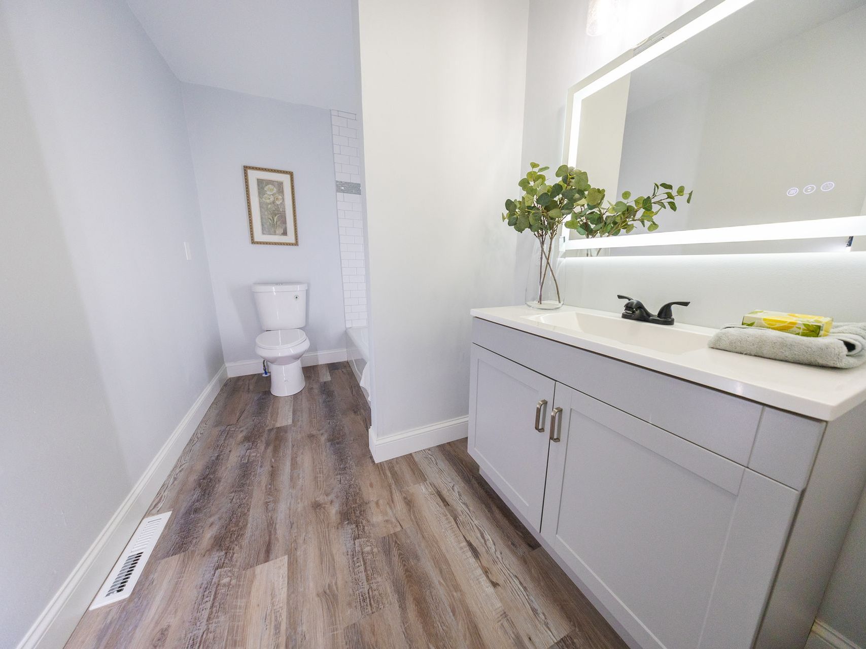A beautiful new bathroom with a toilet, sink and mirror.