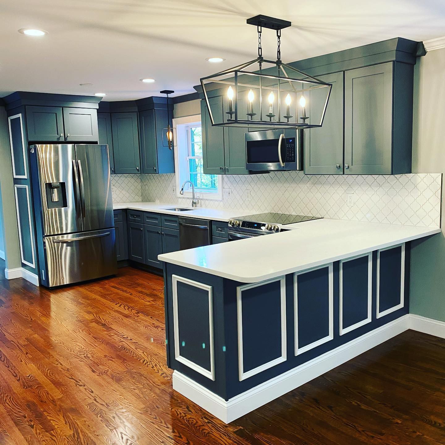 A kitchen with stainless steel appliances and blue cabinets