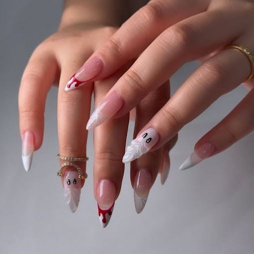 Hand with long almond-shaped acrylic nails in pink, white, and silver designs