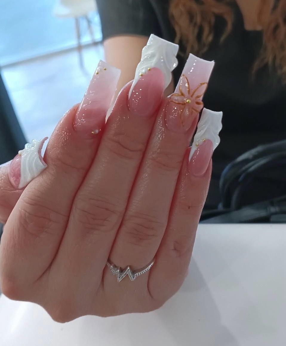 Hand with long pink nails holding a white tissue, wearing a silver ring with a star accent.