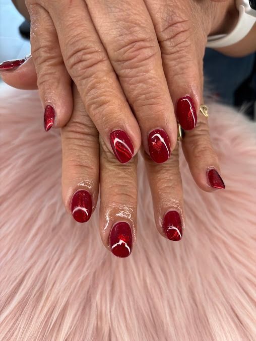 Hands with red manicured nails resting on soft pink fur