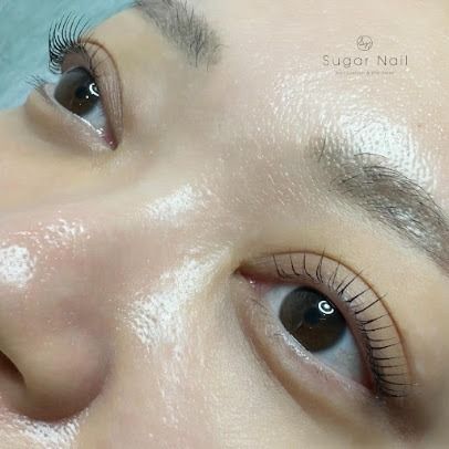 Close-up of a person’s eyes with long lashes and dewy skin, looking upward.