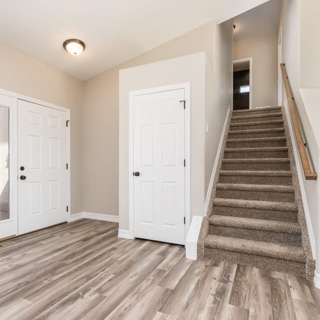 A hallway with stairs leading up to the second floor