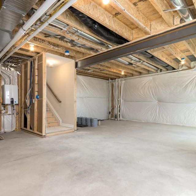An empty basement with a staircase leading up to the second floor