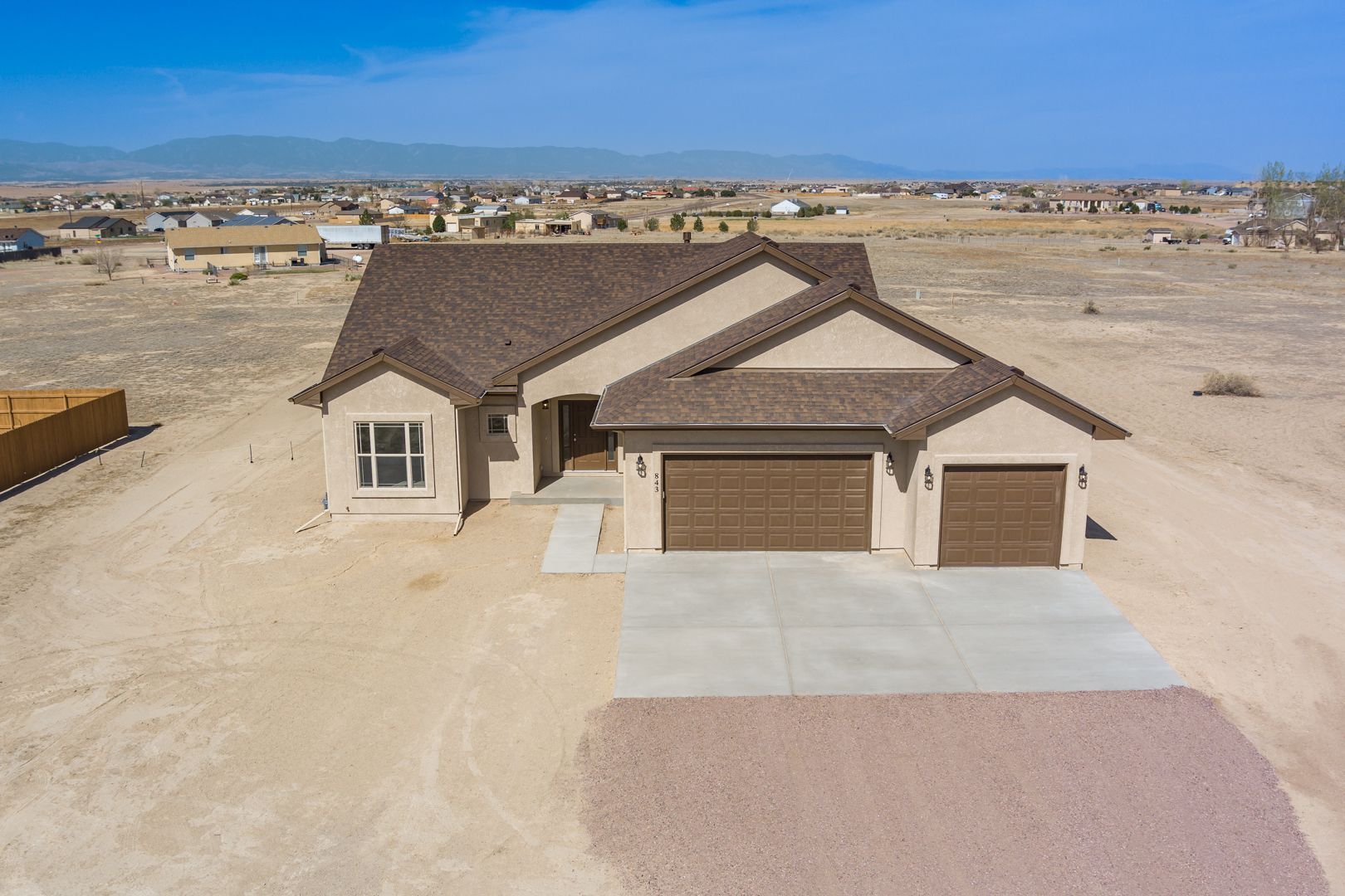 An aerial view of a house in the middle of a desert.
