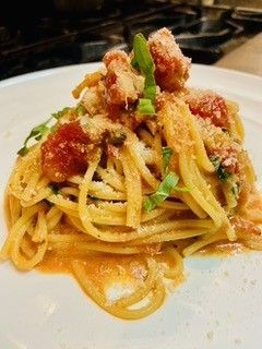 Spaghetti alle vongole with clams and parsley in a white bowl on a rustic table