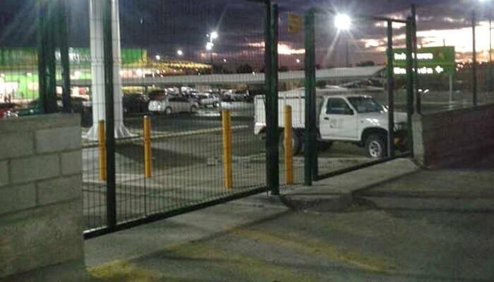 Un camión blanco está estacionado en un estacionamiento detrás de una valla