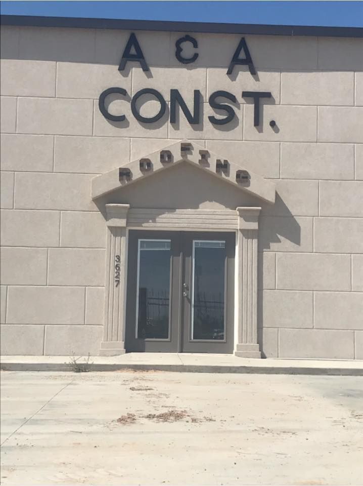 ACA Const. Roofing building with double doors, gray accents, and brick-like facade.