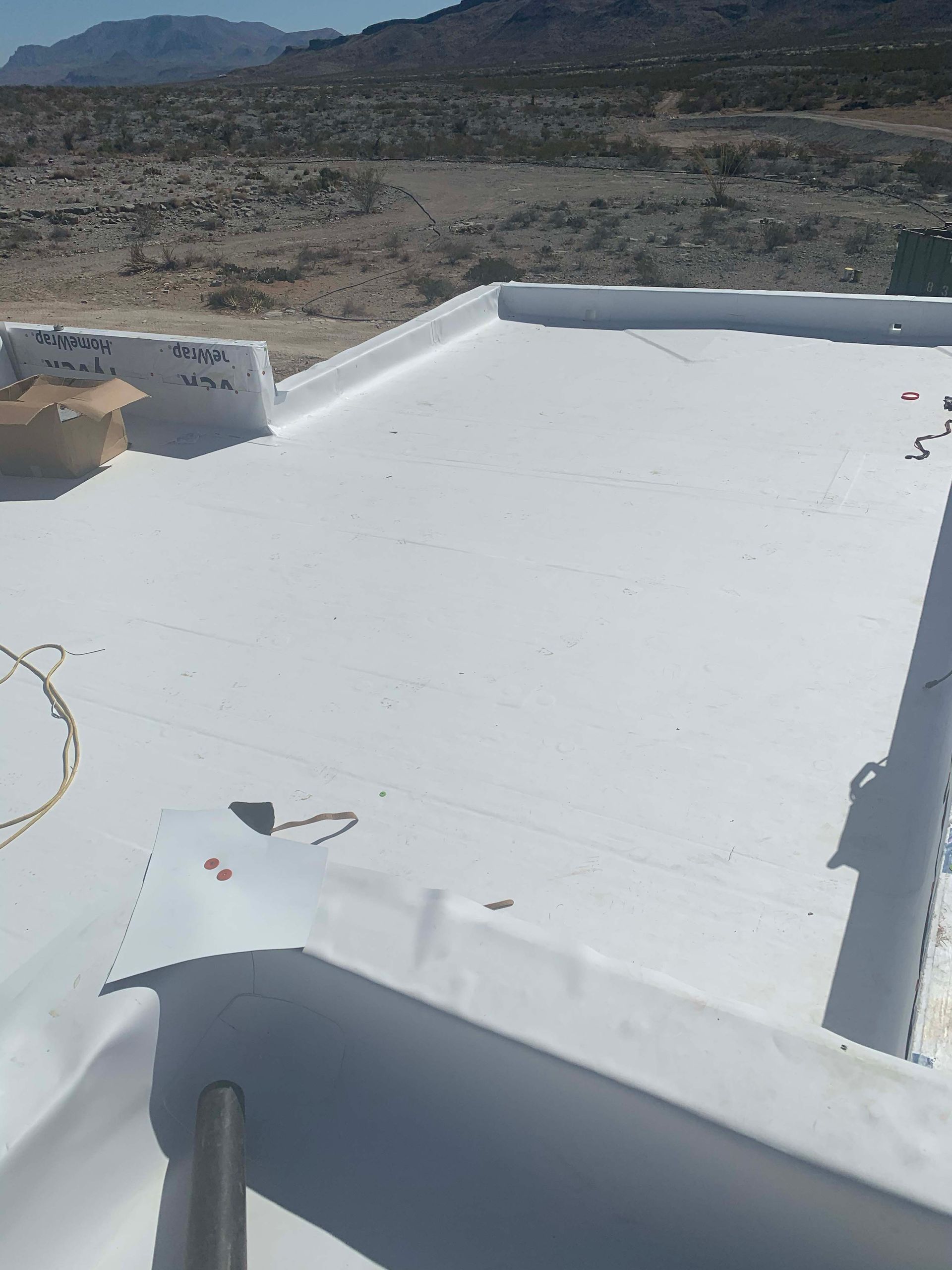 White flat roof with angled edges, in a desert landscape.